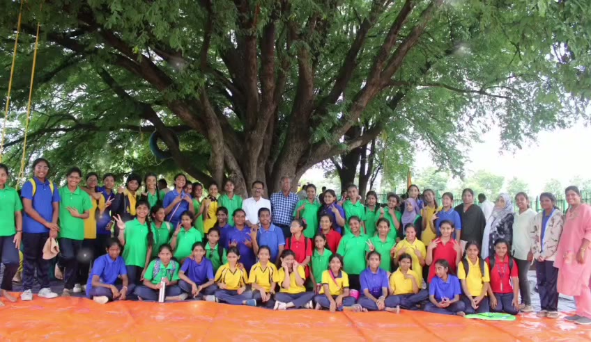 Students and teachers gathered together under the campus tree